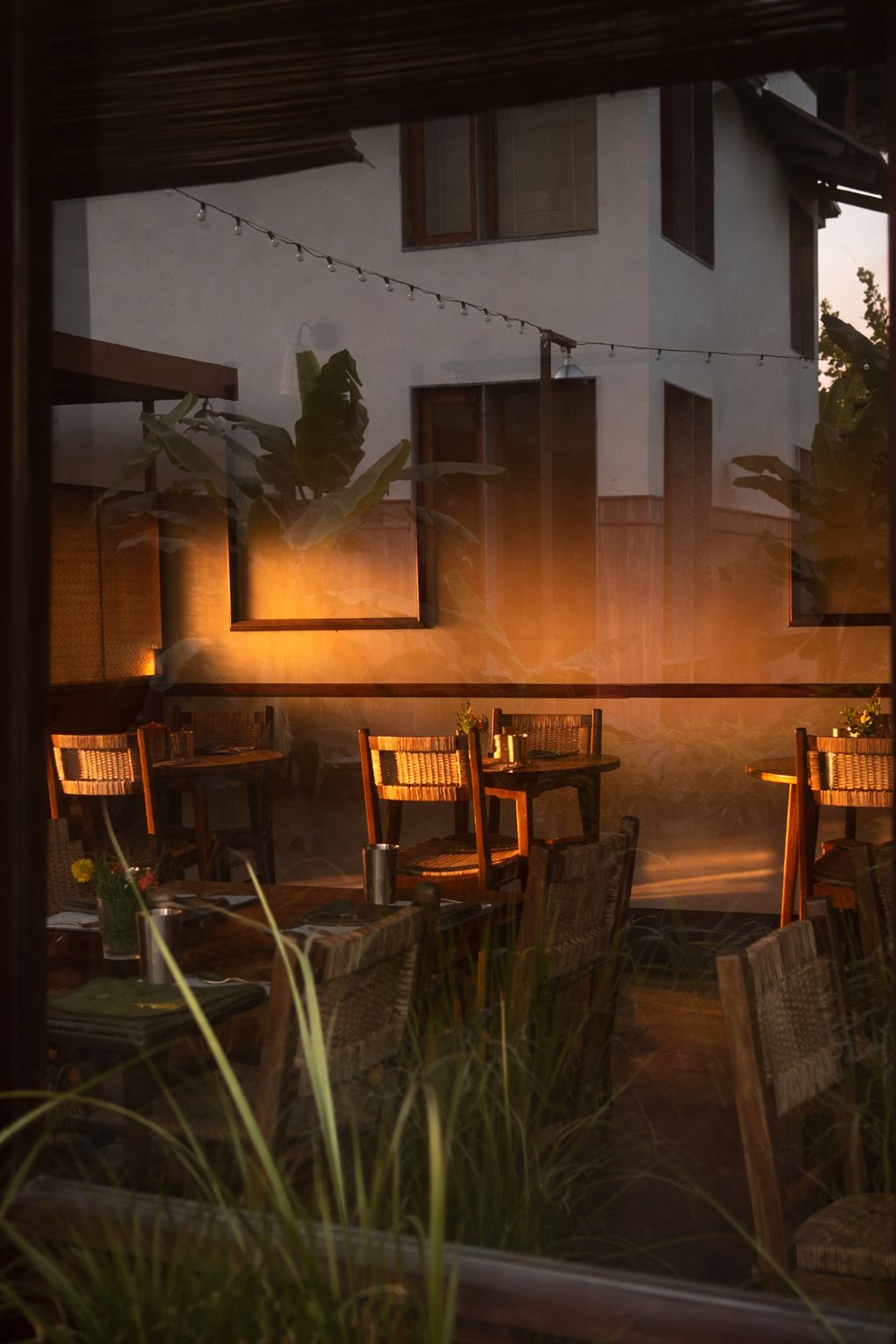 Dining tables set for the evening seen through a window