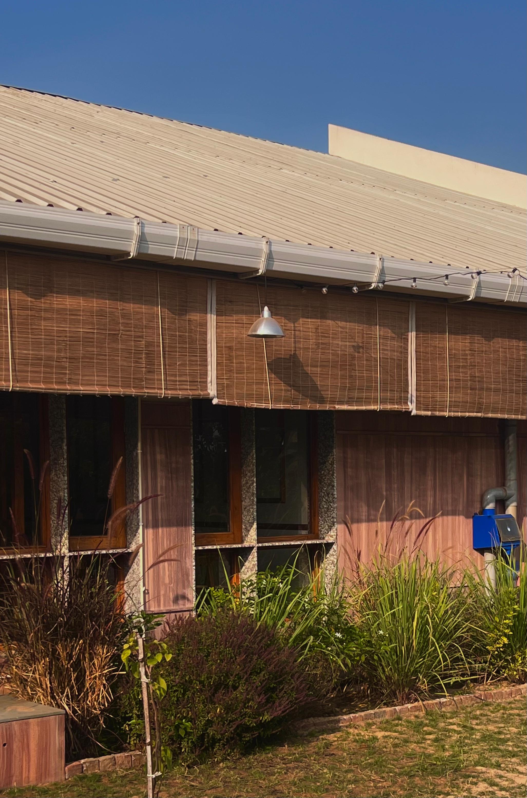 Building facade with bamboo blinds and metal roof